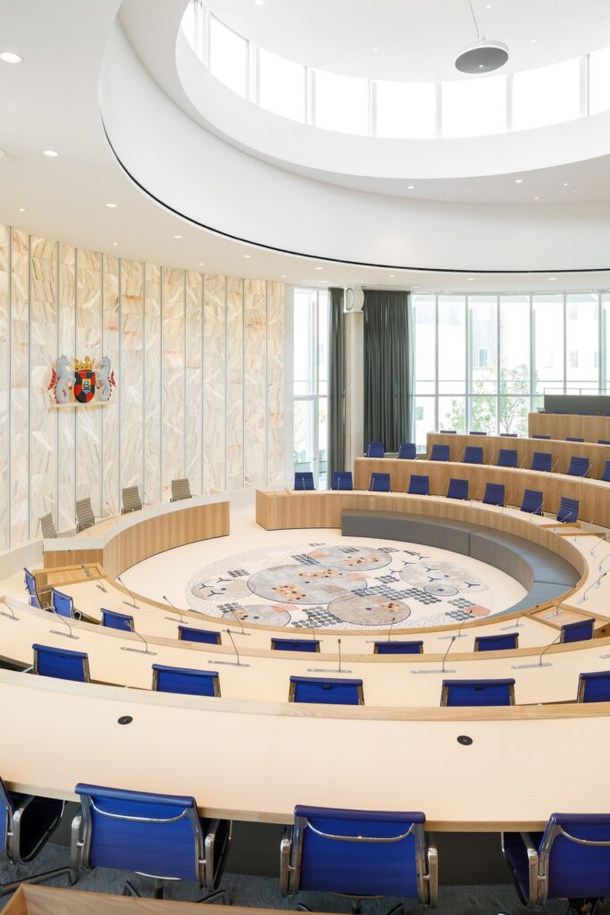 The wooden rings provide a gentle backdrop framing the council members during meetings.