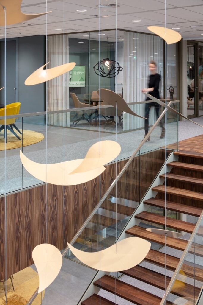 Meeting hub with custom pendula above stairs
